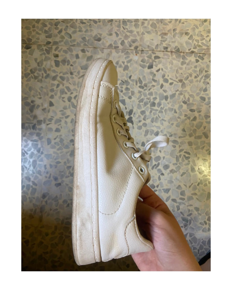 Dirty yellowed white shoe